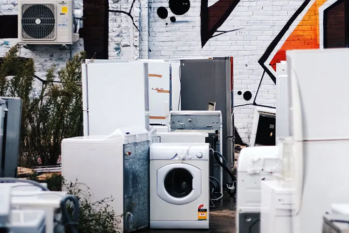 A bunch of appliances that are sitting in the dirt.